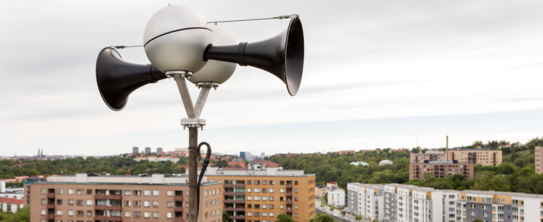 Utomhuslarmet Hesa Fredrik på en hög byggnad. I bakgrunden syns hustak.