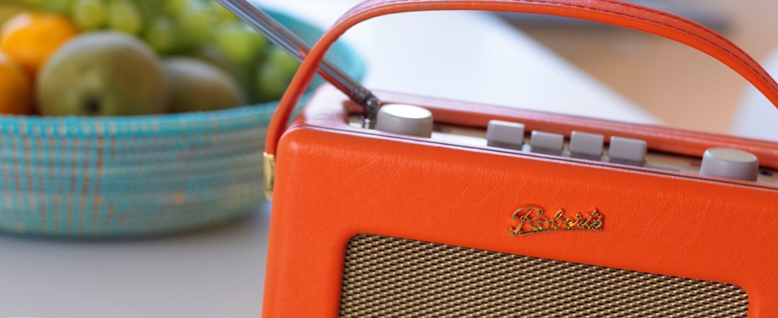 Radioapparat på köksbord med en fruktskål.