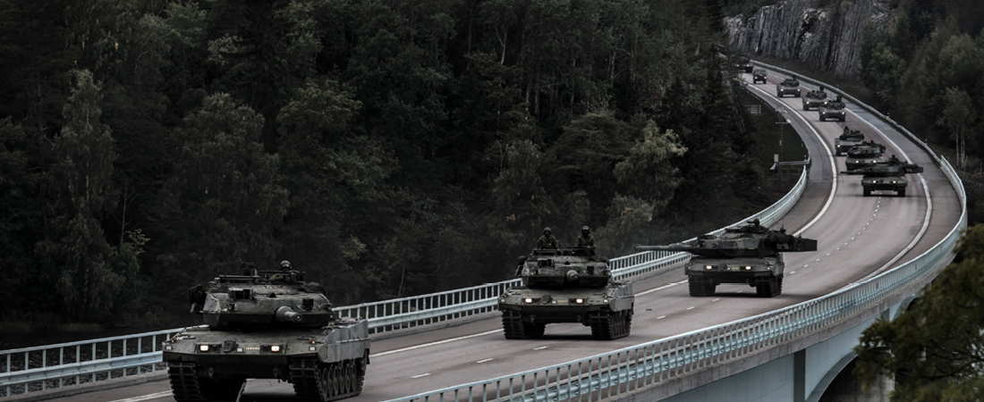 Militärfordon åker på bro. 