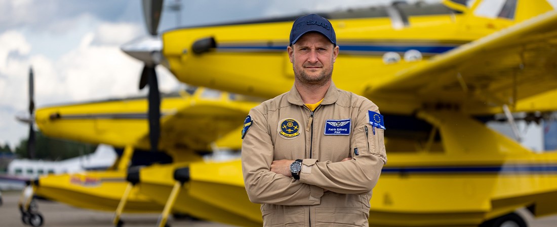 Brandpiloten Patrik Sjöberg står framför ett gult flygplan.